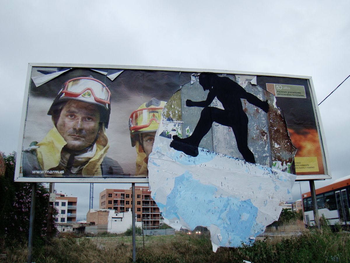 Billboard advertisement for firefighters torn open to reveal a black silhouette of a running figure leaping through the gap, city buildings and a bus visible behind.