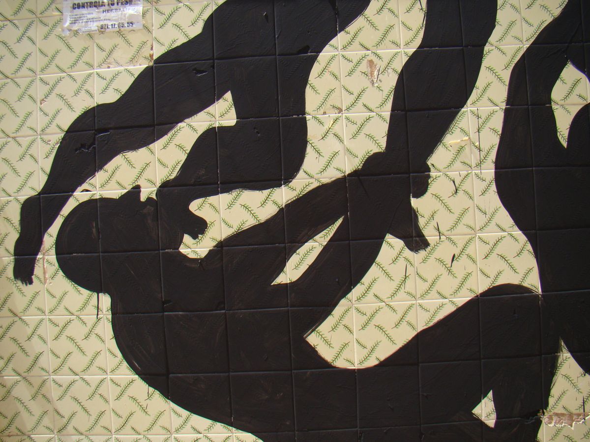Weathered wall with a wooden shuttered window above bare stone and plaster, a small black silhouette of two raised arms and a head reaching up from the bottom right corner as if climbing out of the ground.