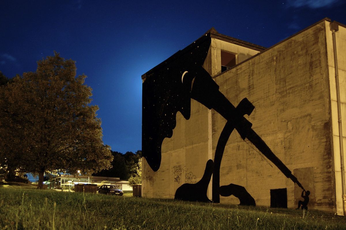 Wide view of the OBSERVER mural showing the full building facade, with the starry silhouette above and the small telescope-facing figure on the ground below.