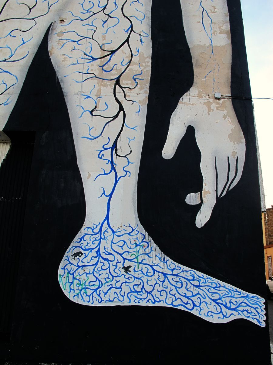 Close-up of the same figure's lower leg and hand rendered in white with blue branching vein-like lines, set against the black silhouette background.