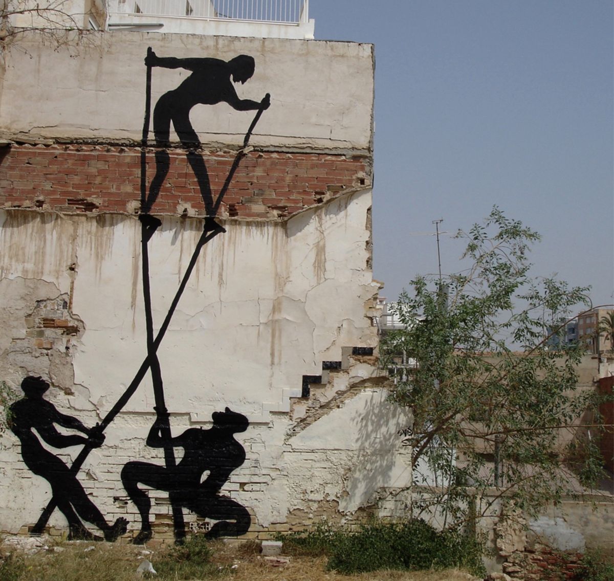 Black silhouette of a large round shape resembling a mosquito or head painted on a rolled-down metal shutter, connected to a bent walking figure covering its face, a child and a woman standing on the sidewalk nearby.