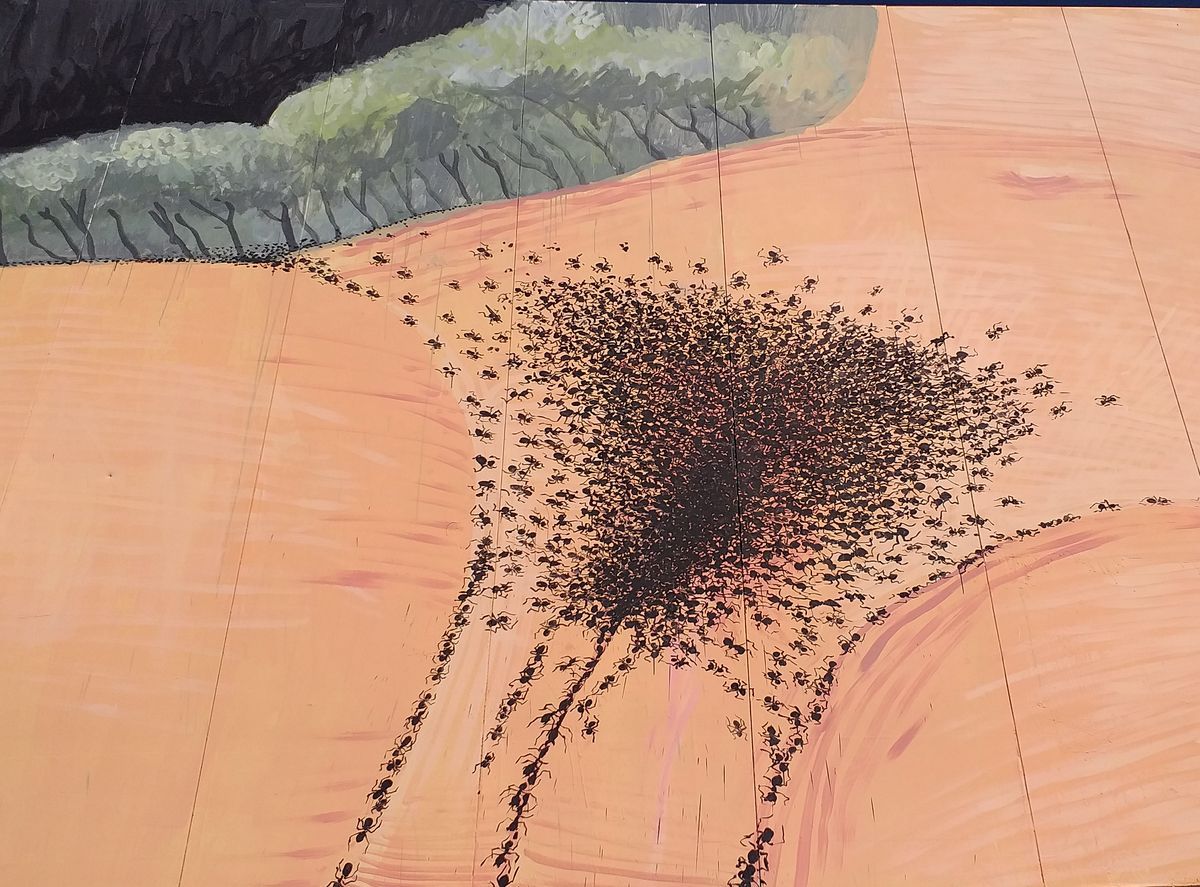 Close-up detail of hundreds of painted black ants converging into a dense central cluster on a peach-colored surface, a nod to Gustave Courbet's L'Origine du monde, with thinner trails of ants branching outward and downward across the textured wood panels.