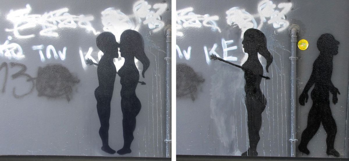 Two-panel black silhouette stencil on a grey metal wall: the left panel shows a nude couple facing each other about to kiss, the right panel shows a woman with an arrow through her body reaching toward a walking male figure, both panels set against white spray-painted graffiti.
