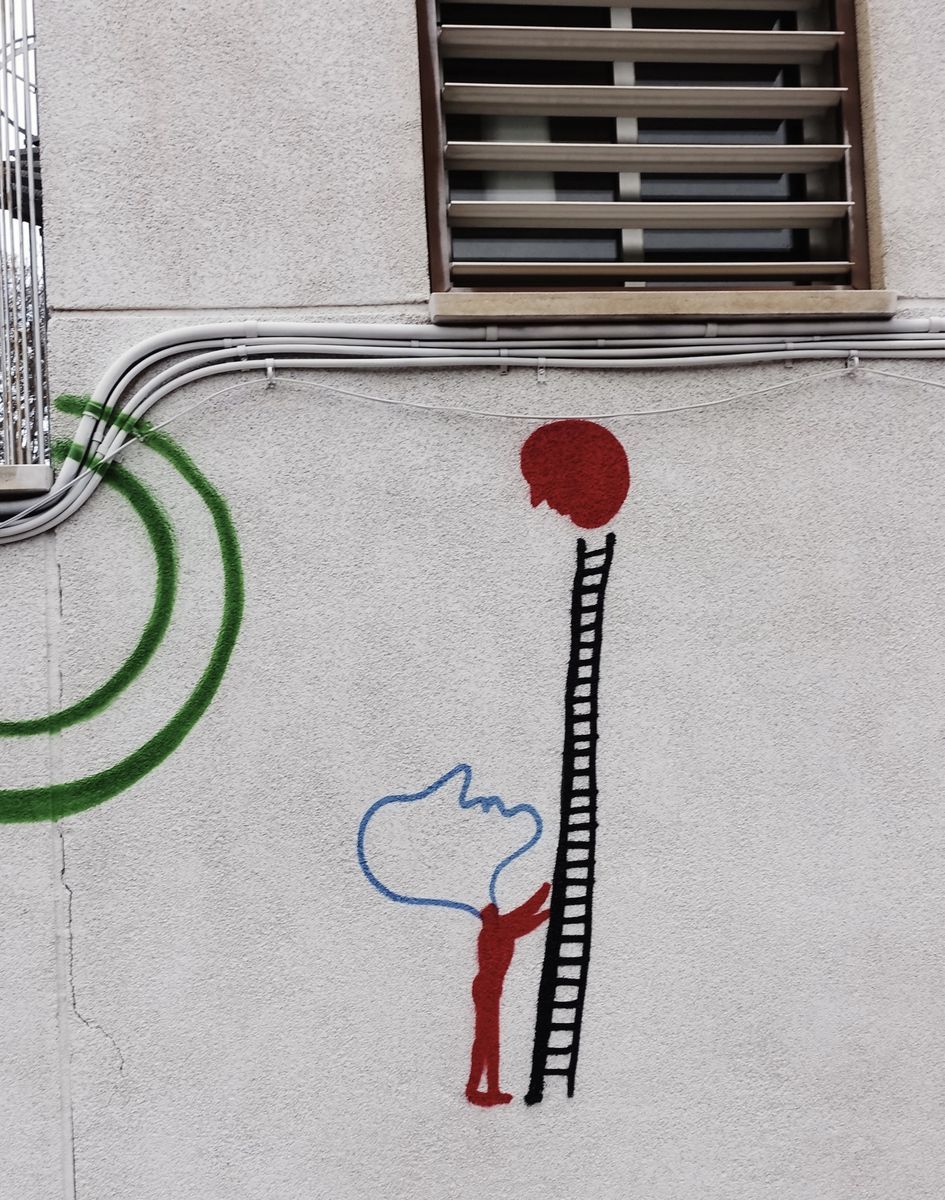 Painted detail of a red circular head figure climbing a tall black ladder, a blue speech-bubble-shaped cloud and green spiral beside it on a textured wall.