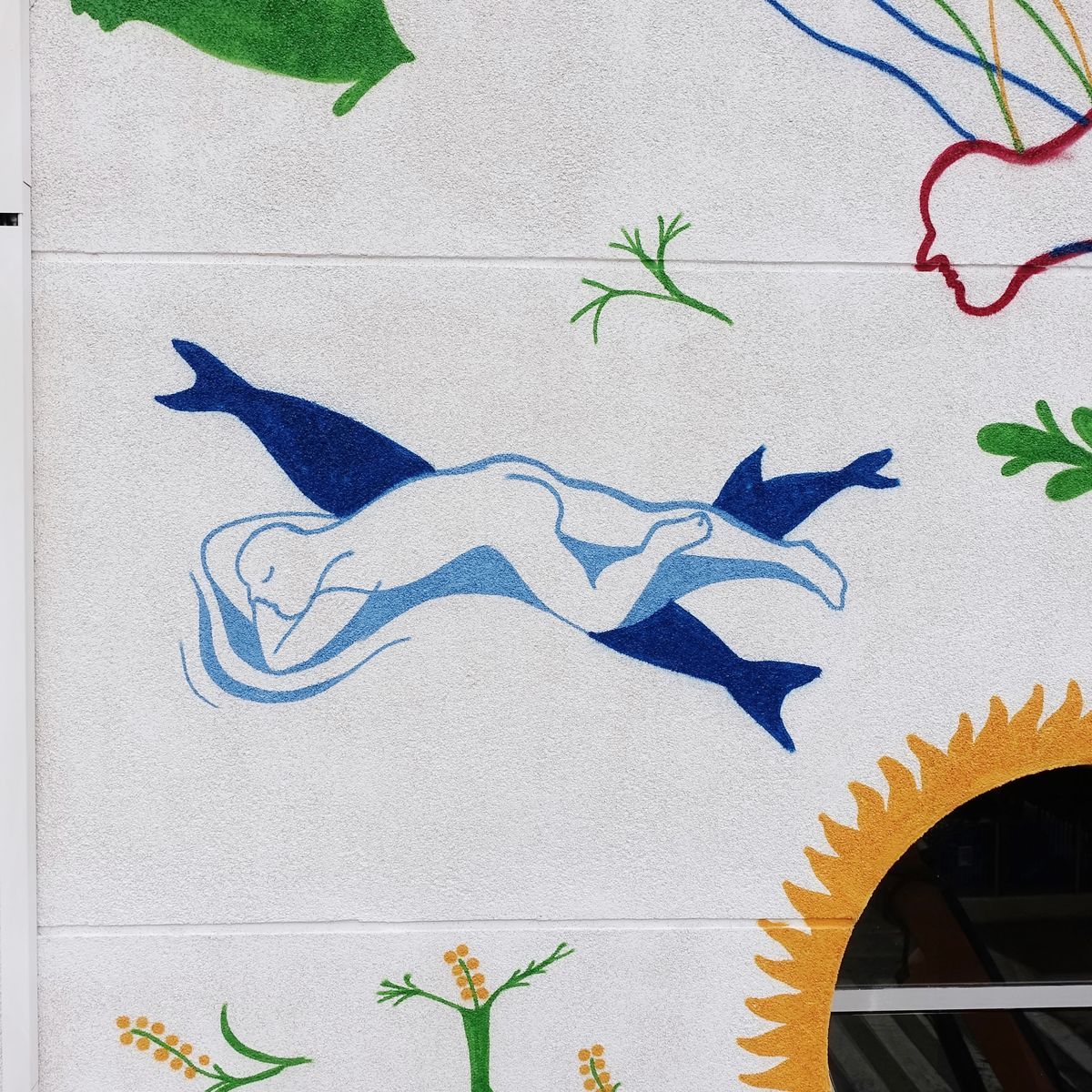 Painted detail of a blue swimming female figure with fish-tail-like wings, dolphins style, surrounded by small sprigs of foliage and part of a orange sunburst circle.
