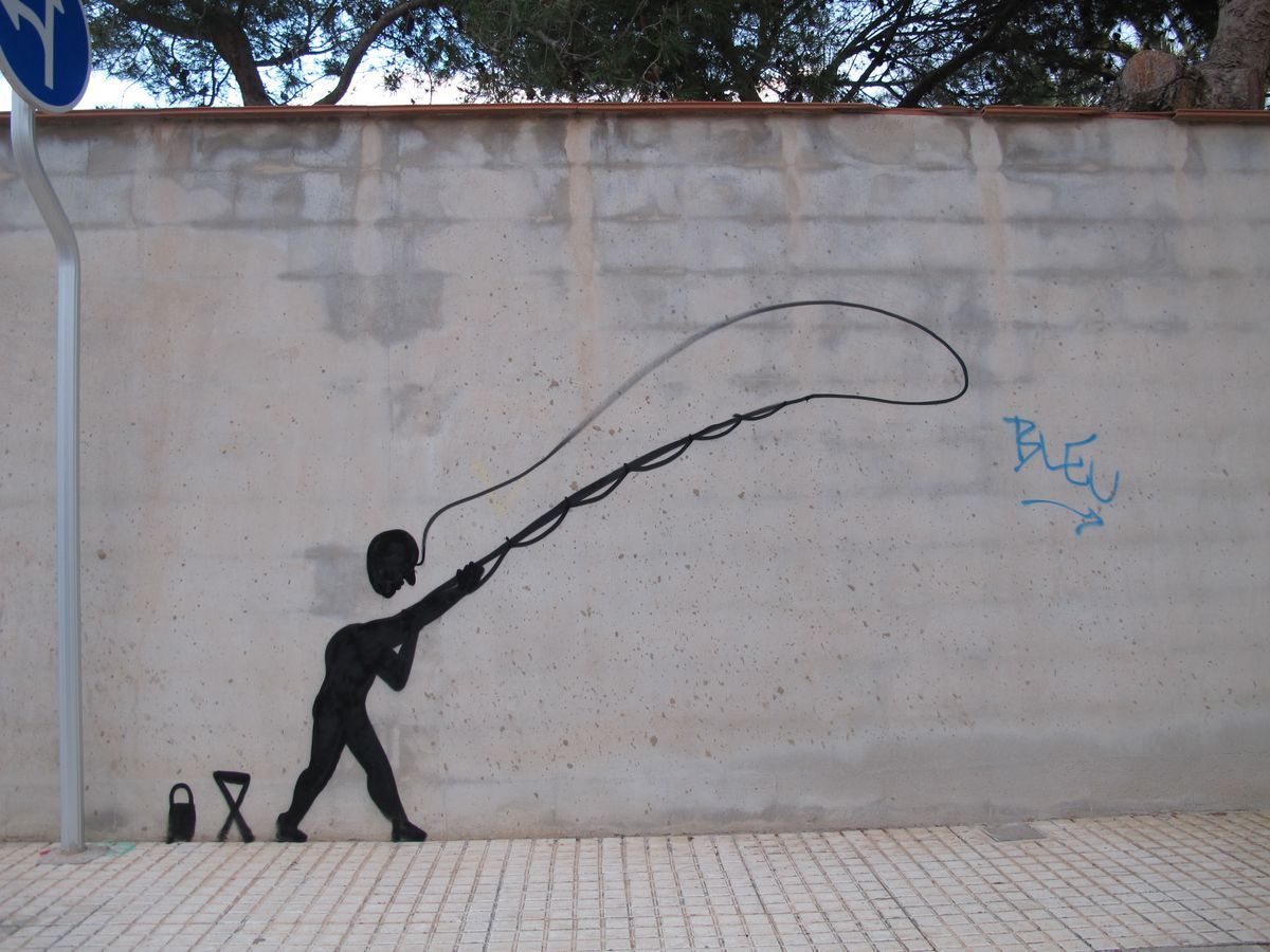 Black silhouette of a leaning figure casting a long looping fishing line along a concrete wall, a bucket and folding stool on the ground beside it, a traffic sign and trees above.